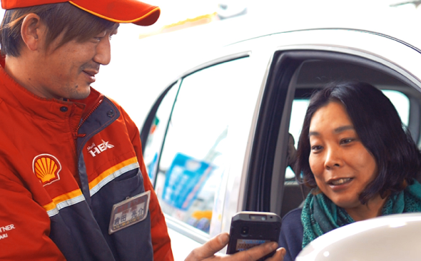 写真：運転席のお客様とコミュニケーションをとるスタッフの様子