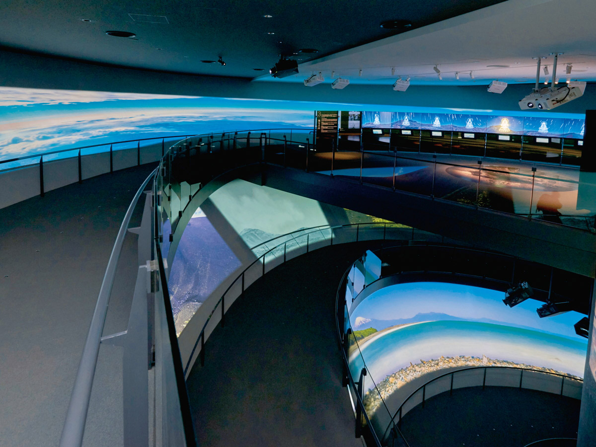 写真：1階から5階までらせんスロープでつながった展示棟。富士山に関するさまざまなテーマに応じた映像が、多数のプロジェクターやディスプレイで映し出されている