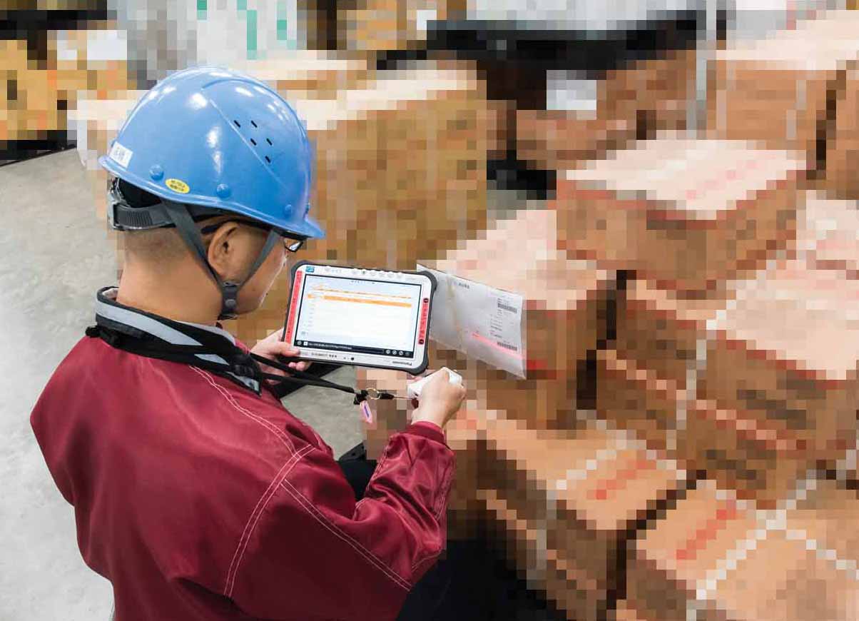 写真:荷札のバーコードをリーダーでスキャンすると、Bluetooth経由でTOUGHPADに情報が送られ、システムで照会された伝票情報が画面に表示されます。