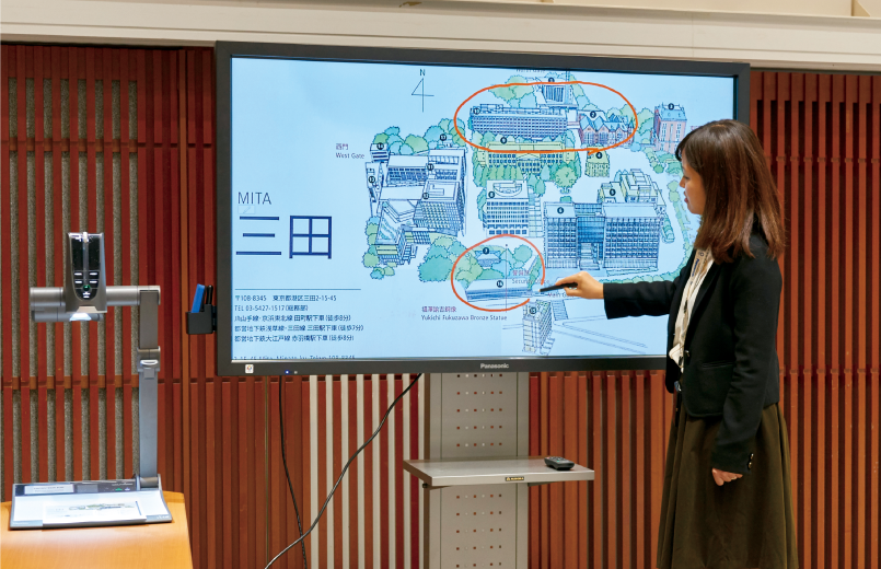 写真:電子黒板を使用して説明する女性の様子。