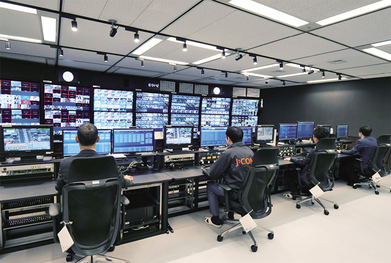 写真:メインの操作卓2卓、サブの操作卓6卓で 構成された放送センター。前方に全国の 送出状況を全て表示する画面を配置