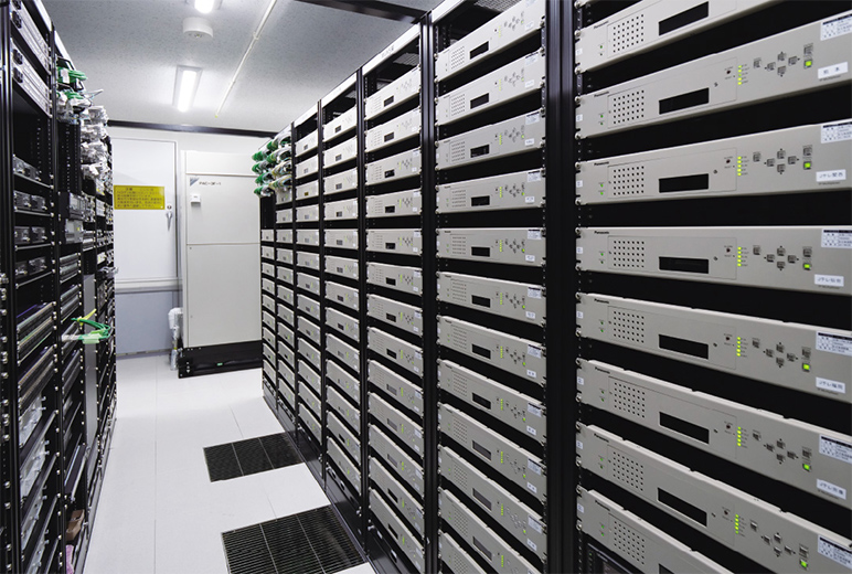 写真:7台のラックに収められた合計83台の IP-MUX装置