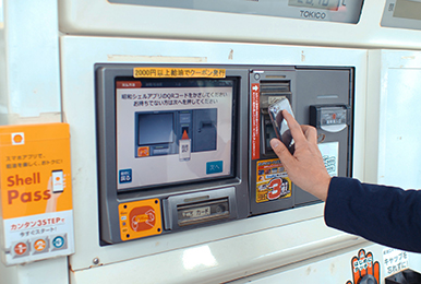 写真:お客様自身が自分のスマートフォンのQRコードを店頭端末にかざしてチェックインを行う様子。
