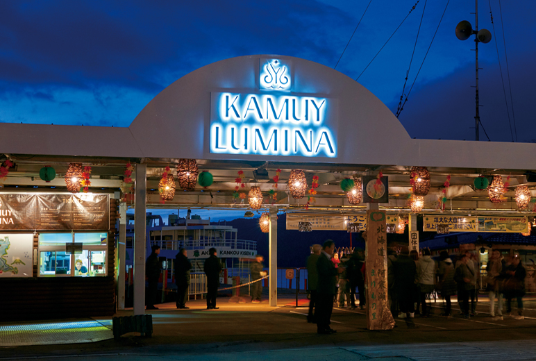 写真:日が暗くなり発着所のゲートの『KAMUY LUMINA』部分が点灯する様子。