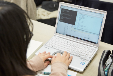 写真:レッツノートを使用してプログラムのコード入力している様子。