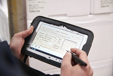 写真:箱に記載されたバーコードをスキャナで読み取ると、タフパッドに商品情報が表示される。タッチペン使用し数量など必要事項を入力。