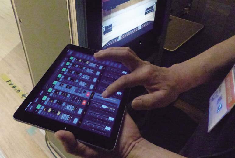 写真:舞台袖からiPadにて音を危機ながらフェーダー操作をする様子