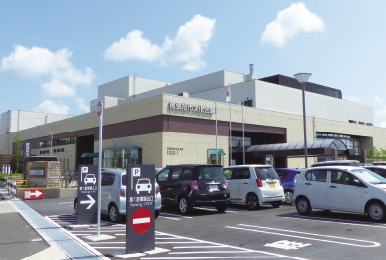 写真:尾張旭市文化会館様の外観。駐車場に沢山の車が停まっている。