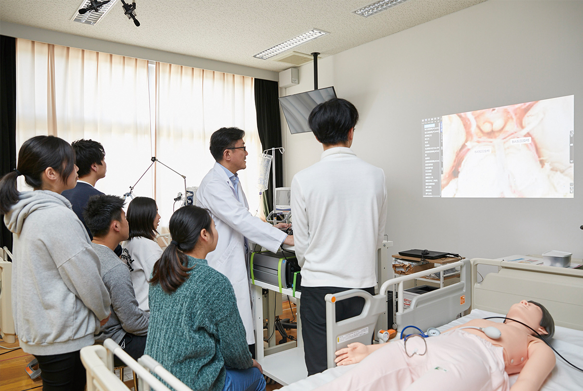 写真:壁に映し出した3D実写映像を確認しながら授業している様子。