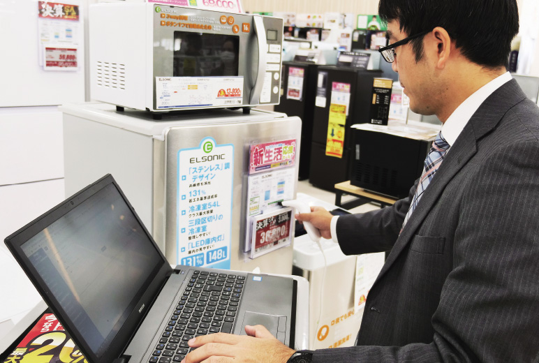 写真:冷蔵庫に貼られたバーコードをスキャンしている様子。