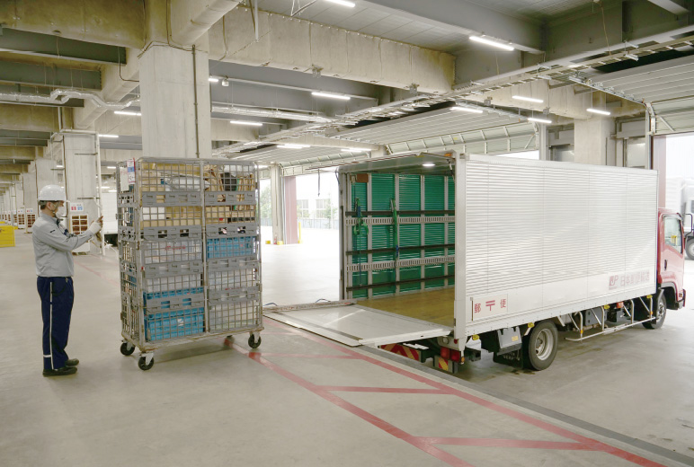 写真：ドライバーはスマートフォンでパレットの二次元コードを読み取り、トラックへ積込  (積載予定ではないパレットの二次元コードを読み取るとアラート通知)