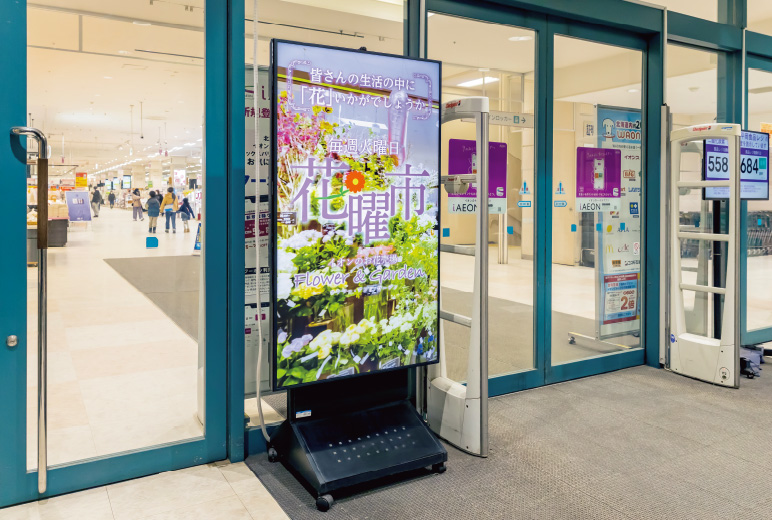 写真:各店舗のメインエントランスには65型や55型の巨大なサイネージを設置し動画で情報発信。