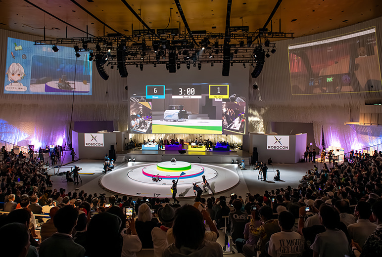 中央モニターに会場内の映像、左右には各チームが制作したバーチャル映像を表示