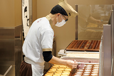 御座候様では、⽣地の製造から焼き上げまでを各店舗で⾏い、できたての商品をその場でお客様に提供。
