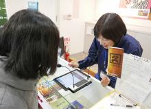 写真：カウンターを挟んで「対面ホンヤク」でお客様と会話をする様子