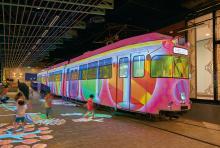 写真：3両編成の車体と床面にダイナミックでカラフルな映像が投写されるプロジェクションマッピングは1日に4度行われ、子供から年配の方まで多くの来場客に楽しまれている