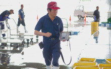 写真:魚市場の職員が荷受けした魚の選別・計量を行っている様子。腰に付けたモバイルプリンターからは生産者に渡す受領書を発行する。